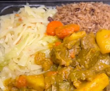Curry goat with cabbage and rice and peas